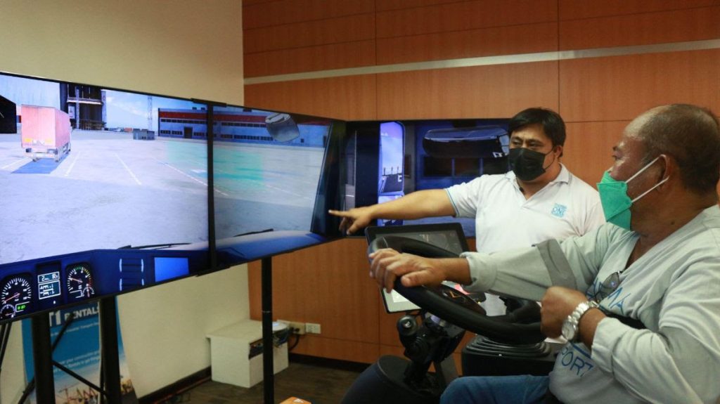 Kiko Oyos (in white) trains truck driver Allan Tiloy (click the photo to watch the simulator in action)