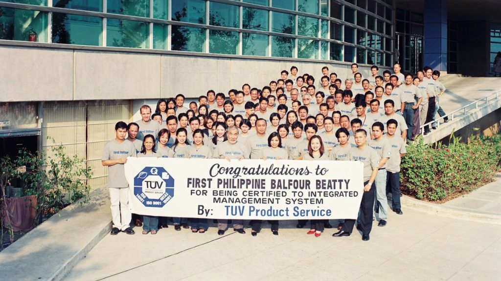  A group photo taken in 2003 to celebrate its first year of being triple ISO-certified to the three standards. This was taken in then First Philippine Balfour Beatty's headquarters in the Hatch Asia Building in BGC Taguig.  